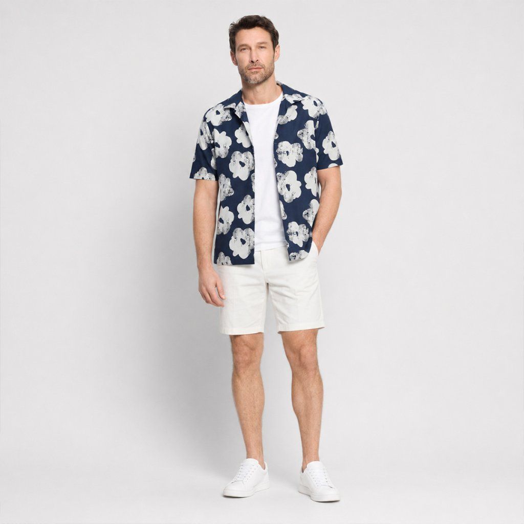 Styling tmavomodrej košele OLYMP Casual s oversized kvetovým printom a bielymi bermudami